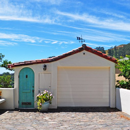 a small white home on a hillside